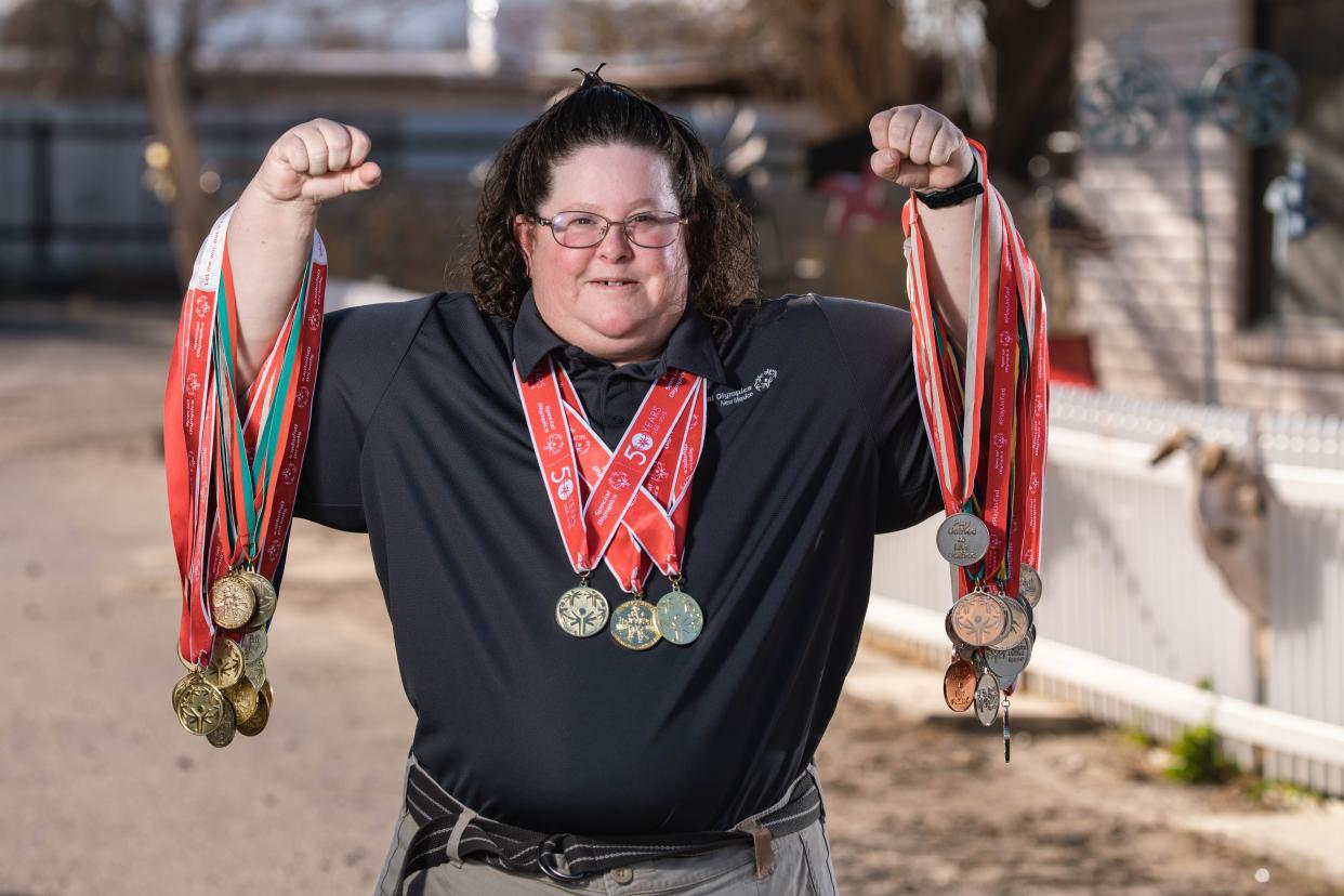 Jenny Matsler, a 43-year-old Special Olympian, holds the gold medals she's won over the years while standing in front of her home in Las Cruces on Wednesday, Jan. 26, 2022. Matsler will be competing in the national Special Olympics this June.