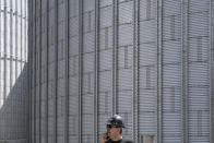 Dan Dolghin, director of the cereal operation at the Comvex handling and storage facility, speaks on the phone backdropped by silos in the Black Sea port of Constanta, Romania, Tuesday, June 21, 2022. While Romania has vocally embraced the ambitious goal of turning into a main hub for the export of agricultural products from Ukraine, economic experts and port operators in the country warn that it was much easier objective to set than to actually achieve. (AP Photo/Vadim Ghirda)