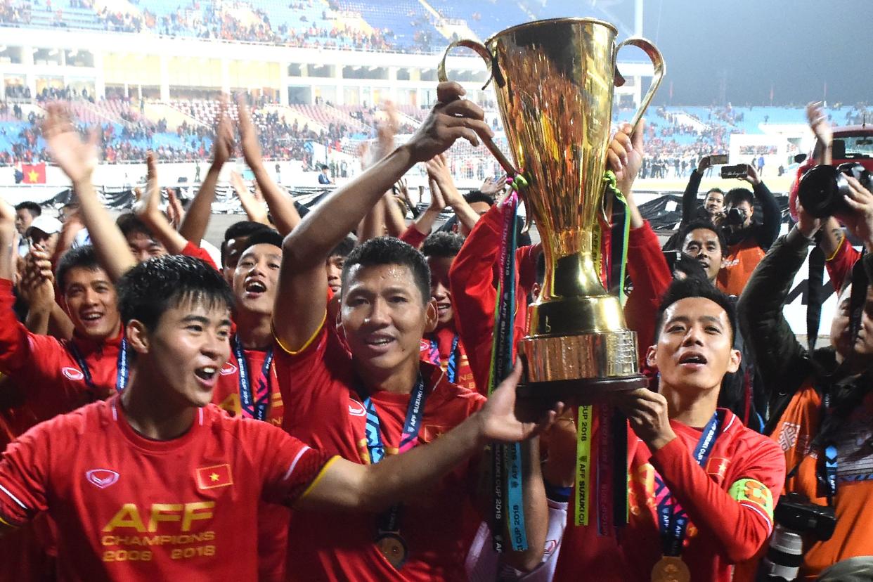 Vietnam's forward Nguyen Anh Duc (centre) and teammates hold the trophy as they celebrate after winning the AFF Suzuki Cup 2018 final.