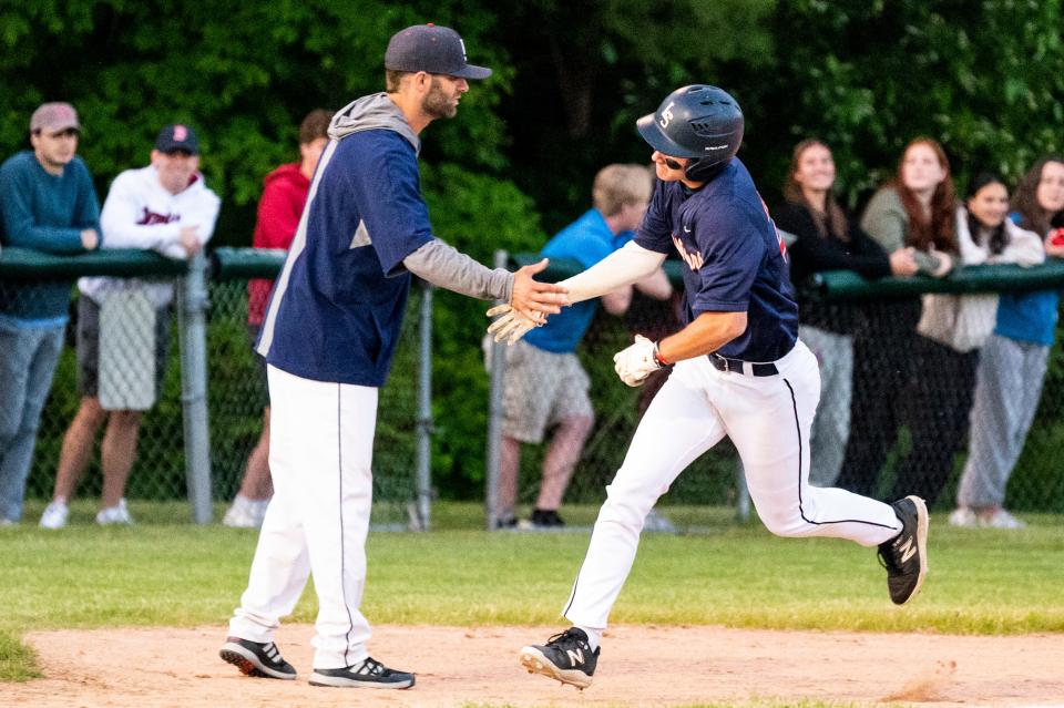 After hitting a home run, Lincoln-Sudbury shortstop Jake Haarde celebrates running past third base with head coach Matt Wentworth, during the opening round of the Rich Pedroli Daily News Classic game against in Natick, May 25, 2023.