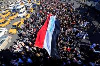 University students carry an Iraqi flag, during ongoing anti-government protests in Baghdad