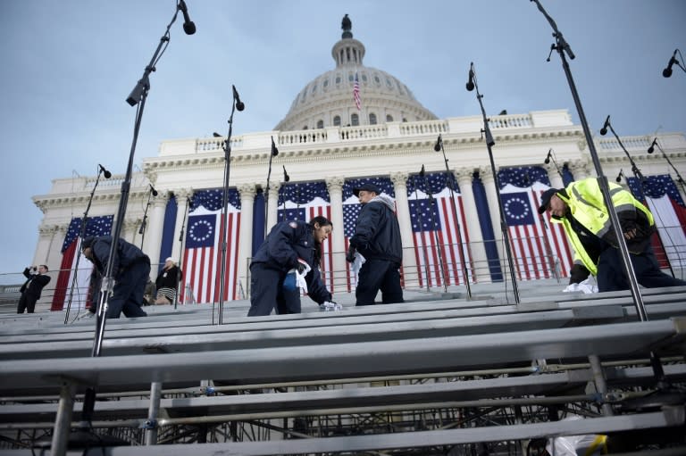 Workers prepare spectators' seats below the dome of the US Capitol in Washington, DC on January 20, 2017, before the swearing-in ceremony for US President-elect Donald Trump