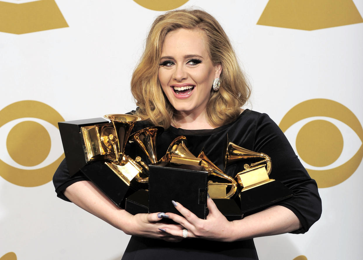 FILE - This is a Sunday, Feb. 12, 2012  file photo of Adele  as she poses backstage with her six awards at the 54th annual Grammy Awards on Sunday, Feb. 12, 2012 in Los Angeles. Adele won awards for best pop solo performance for "Someone Like You," song of the year, record of the year, and best short form music video for "Rolling in the Deep," and album of the year and best pop vocal album for "21." Adele is getting a new medal to go alongside her Grammys and Academy Award _ an honor from Queen Elizabeth II. The "Rumor Has It" and "Skyfall" singer was named a Member of the Order of the British Empire, or MBE on Friday June 14, 2013  in the queen's annual Birthday Honors list. (AP Photo/Mark J. Terrill, File)