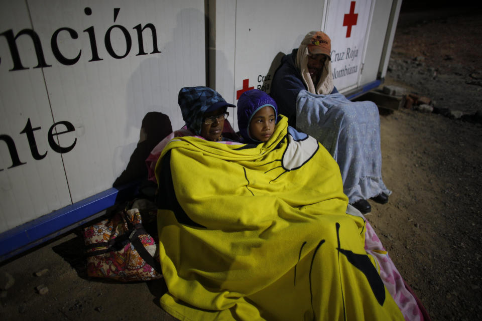 In this Aug. 31, 2018 photo, Venezuelan Sandra Cadiz rests with her 10-year-old daughter Angelis on a dirt floor near a gas station in Pamplona, Colombia, on their journey to Peru. Cadiz took out her life savings in Venezuelan bolivars for the trip, and by the time the two reached Lima, they didn't have a cent in their pockets. (AP Photo/Ariana Cubillos)