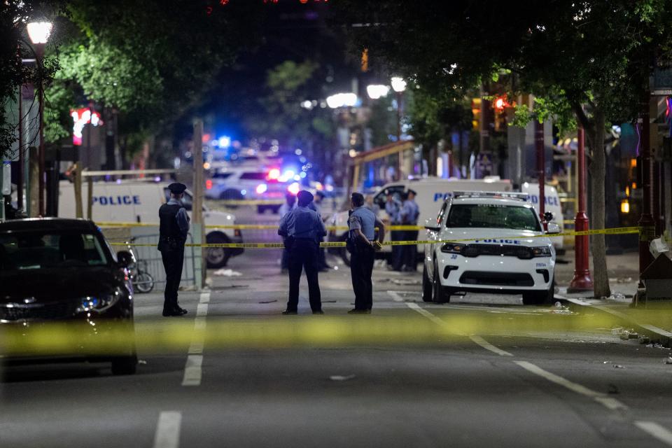 Philadelphia Police officers and detectives look over evidence at the scene of a shooting in Philadelphia, Sunday, June 5, 2022.