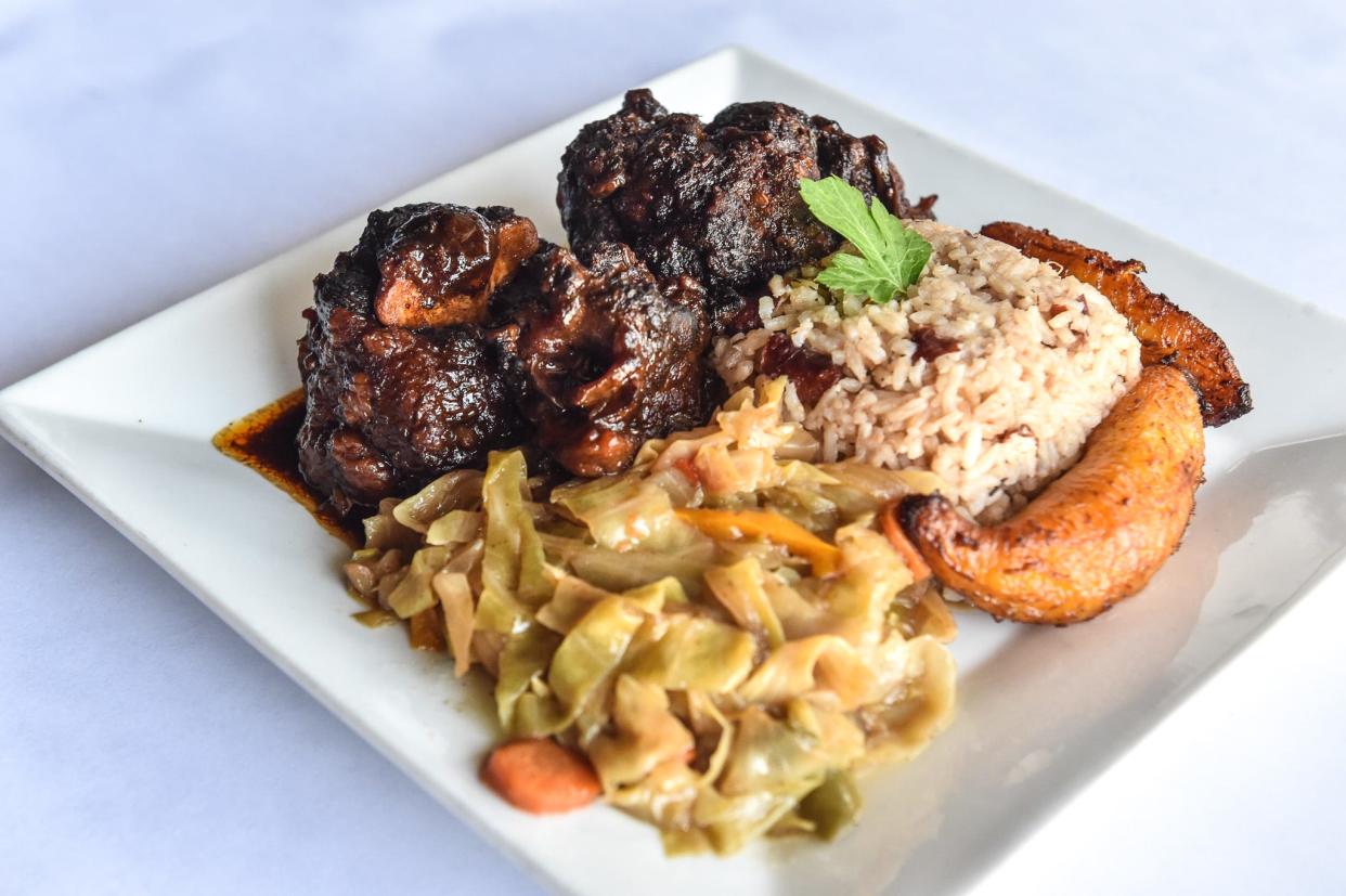 Fall-off-the-bone oxtail served with coconut rice, peas, stir-fried cabbage and sweet plantains is seen at Sambou's African Kitchen in Jackson on Tuesday, Feb. 28, 2023. Many West African restaurants are opening across the Southern United States, introducing new and exciting flavors to the region.