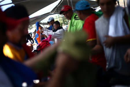 Central American migrants, moving in a caravan through Mexico, receive clothes at a temporary shelter, in Hermosillo, in Sonora state, Mexico April 23, 2018. REUTERS/Edgard Garrido