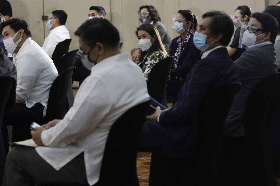 Filipino lawmakers wear face masks as they attend a session before swearing in Rep. Lord Allan Velasco as new house speaker at the Celebrity sports club in Quezon city, Philippines, Monday, Oct. 12, 2020. A large faction of Philippine legislators in the House of Representatives has elected a new leader but the incumbent speaker declared the vote “a travesty” in a tense political standoff between two allies of the president. (AP Photo/Aaron Favila)