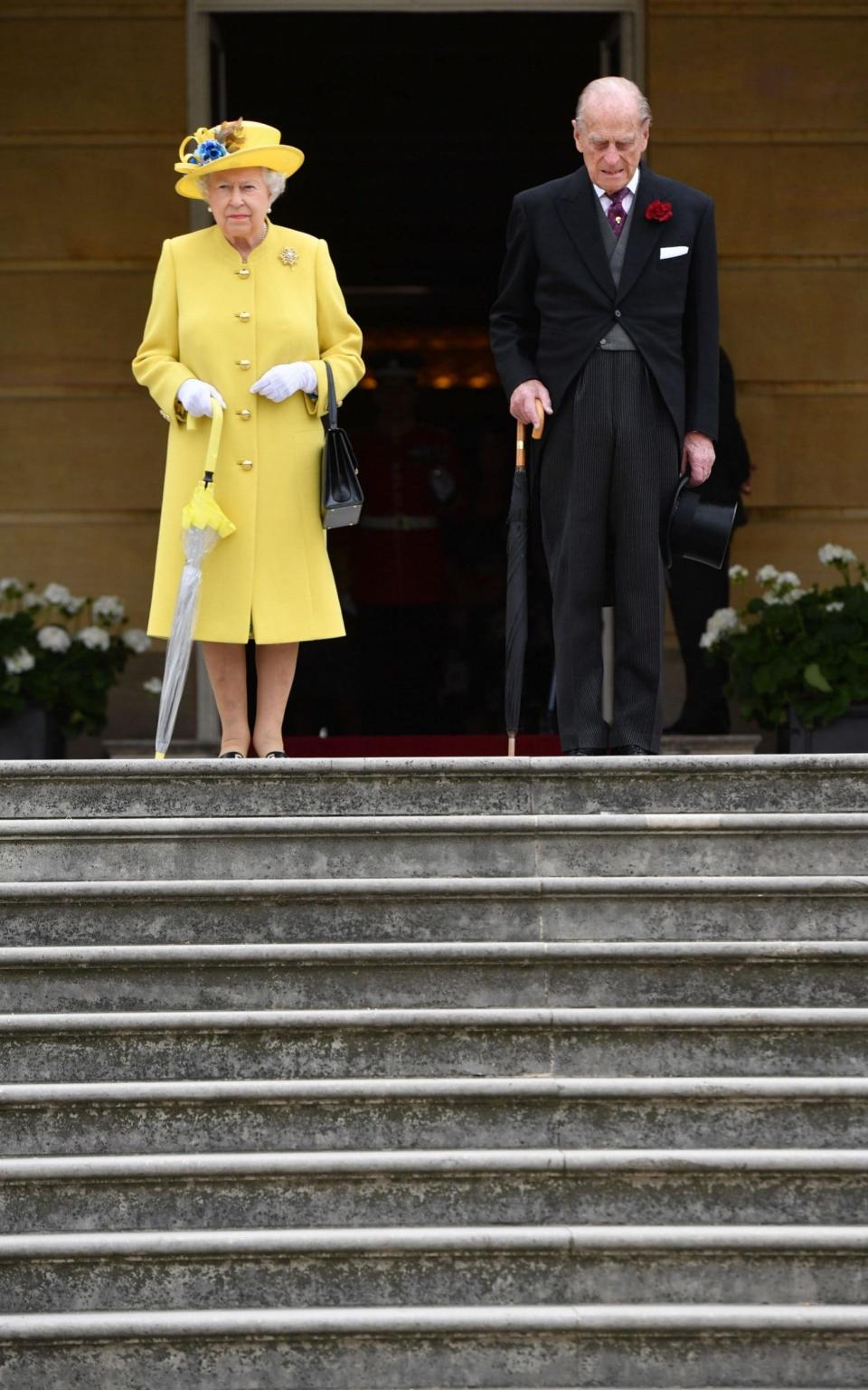 Queen Elizabeth II and the Duke of Edinburgh observing a minute's silence at the start of a garden party at Buckingham Palace in London - Credit: Dominic Lipinski/PA Wire