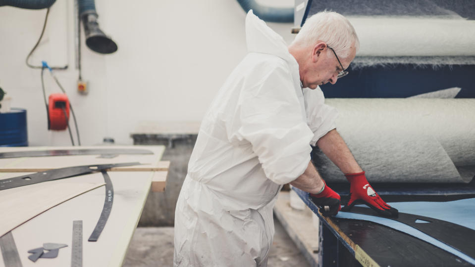 At UK-based coachbuilder Allesley, a craftsman works on composite materials.