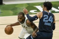 Milwaukee Bucks' Khris Middleton drives past Memphis Grizzlies' Dillon Brooks during the first half of an NBA basketball game Saturday, April 17, 2021, in Milwaukee. (AP Photo/Morry Gash)