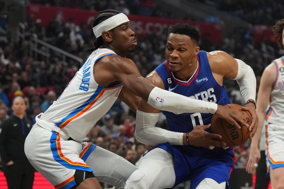 Mar 21, 2023; Los Angeles, California, USA; LA Clippers guard Russell Westbrook (0) is defended by Oklahoma City Thunder guard Shai Gilgeous-Alexander (left) in the first half at Crypto.com Arena. Mandatory Credit: Kirby Lee-USA TODAY Sports