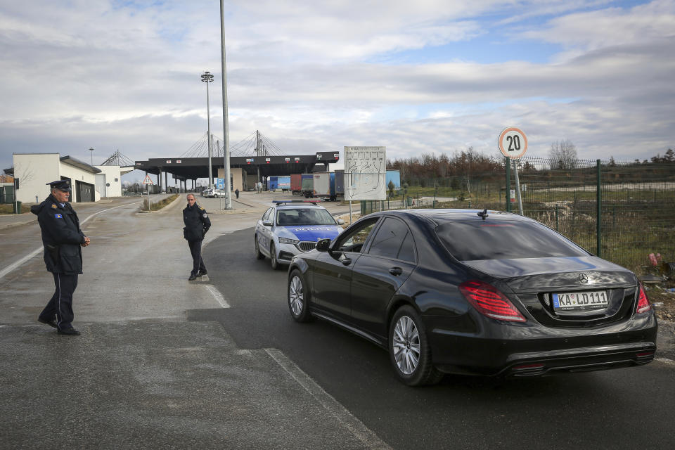Kosovo police officers stop a vehicle at the closed Merdare border crossing between Kosovo and Serbia on Wednesday, Dec. 28, 2022. Kosovo closed the border crossing in Merdare, following an erected barricade by Serb protesters inside Serbia late Tuesday night, the third official border crossing closed this month following rising tensions between Kosovo and Serbia. (AP Photo/Visar Kryeziu)