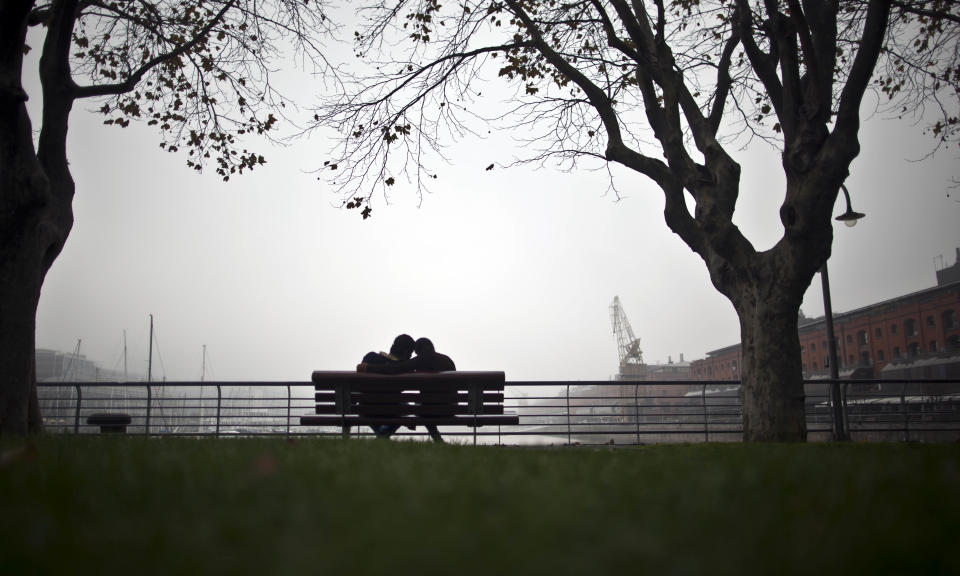 FILE - In this May 28, 2012 file photo, a couple sits on a bench along the waterfront in the Puerto Madero district of Buenos Aires, Argentina. Argentina's leader, Cristina Fernandez, unveiled an ambitious new plan to support the country's television and film creators with a new industrial park along the capital's waterfront that she hopes will be modeled on Hollywood's studios.. (AP Photo/Natacha Pisarenko, File)