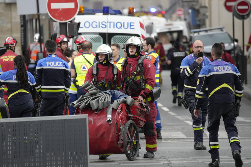 Police officers and rescue workers work at the site of a fire Wednesday, June 21, 2023 in Paris. A strong explosion hit a building in Paris' Left Bank on Wednesday, leaving four people injured and igniting a fire that sent smoke soaring over the domed Val de Grace monument and prompted the evacuation of buildings, police said. The cause of the blast was not immediately known. (AP Photo/Christophe Ena)