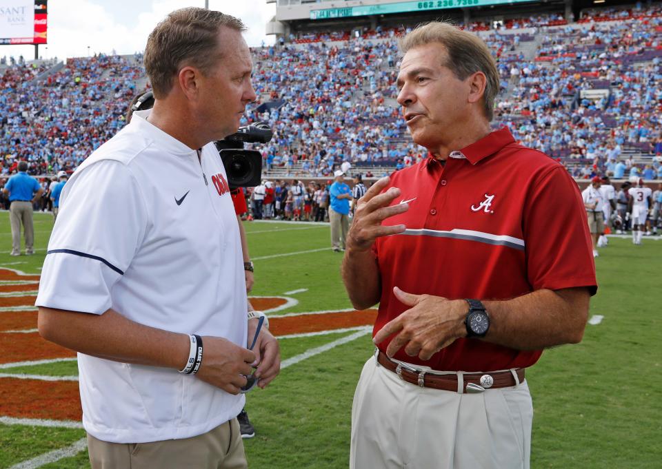 FILE - In this Sept. 17, 2016, file photo, Mississippi coach Hugh Freeze, left, and Alabama coach Nick Saban chat before an NCAA college football game in Oxford, Miss. Southeastern Conference coaches unanimously agree on one topic at the league’s spring meetings this week: They disapprove of NCAA recruiting reforms passed in May. “I think it’s reckless, really,” Freeze said. Added Saban: “Sometimes we take a sledgehammer to kill a fly and it has some unintended consequences, which we may see here sometime in the future.” (AP Photo/Rogelio V. Solis, File)