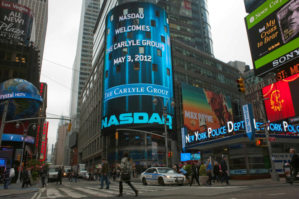 FILE PHOTO: Passersby walk in front of the NASDAQ market site in New York’s Times Square, May 3, 2012. REUTERS/Keith Bedford/File Photo