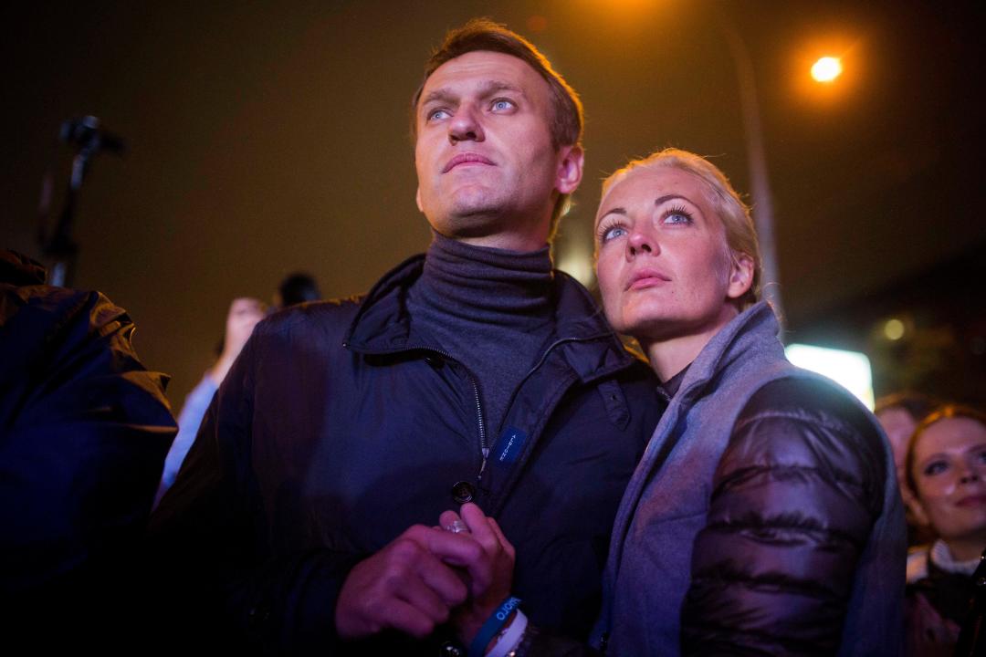 Russian opposition leader Alexei Navalny with his wife Yulia after his last rally in rain-soaked Moscow, Russia, Friday, Sept. 6, 2013. The anti-corruption blogger and a leader of the Russian protest movement, Navalny will face the incumbent Mayor Sergei Sobyanin, in the upcoming Moscow's mayoral election on Sept. 8. (AP Photo/Evgeny Feldman)