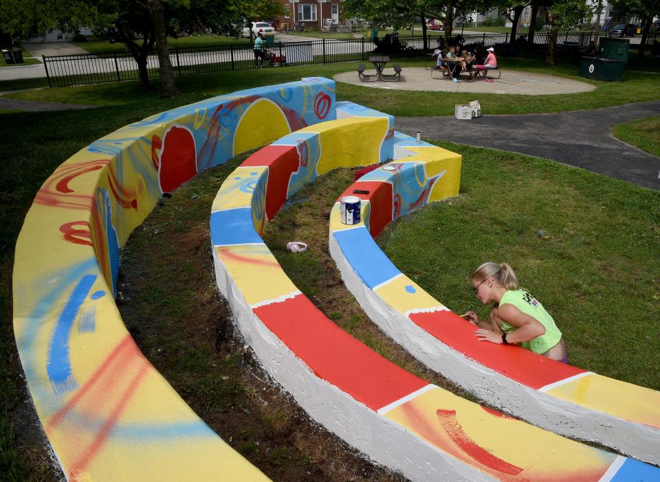 Artist Presley Bergmooser of Monroe is pictured in July putting final touches on silhouette portraits using rich red, blue and yellow colors on her Perspective Mural at Boyd Park in Monroe. The Monroe City Council has approved a new ordinance that defines how public art installations are to be approved and what types of projects are allowed.