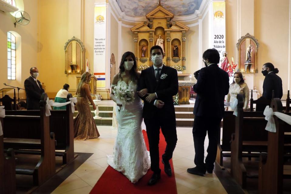 Bride Jazmin Sanabria and her groom Joel Adorno walk down the aisle wearing masks amid the pandemic. 