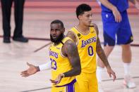 Los Angeles Lakers' LeBron James (23) gestures after an officials call as Kyle Kuzma (0) walks behind in the first half an NBA conference final playoff basketball game against the Denver Nuggets on Friday, Sept. 18, 2020, in Lake Buena Vista, Fla. (AP Photo/Mark J. Terrill)