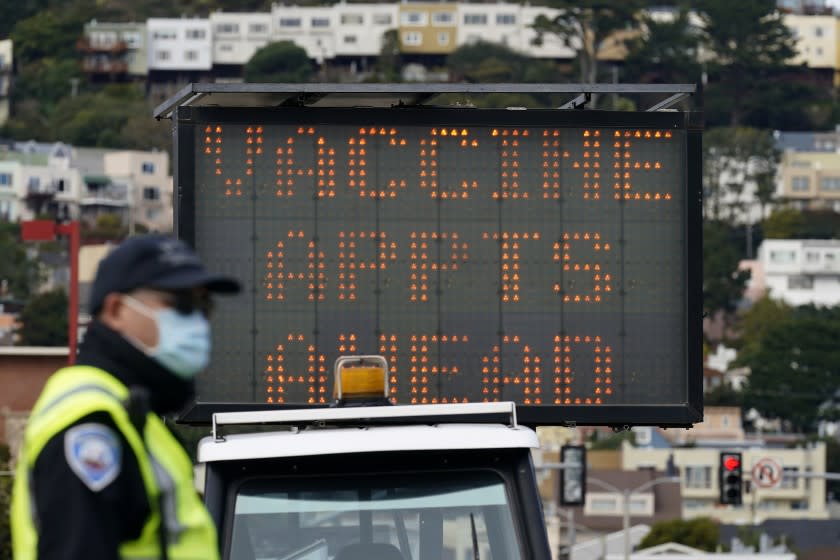 FILE - In this Feb. 1, 2021 file photo an officer stands in front of a sign advising of vaccine appointments at a drive-up vaccination center at City College of San Francisco during the coronavirus pandemic in San Francisco. San Francisco is the latest California city to temporarily shutter a mass vaccination site due to lack of vaccines, joining Los Angeles in pausing inoculations amid a national shortage. Officials said mass vaccinations are on hold at Moscone convention center for one week until supply ramps up. On Tuesday, Feb. 16 two new mass vaccination sites with doses from the federal government will open in Oakland and in Los Angeles. (AP Photo/Jeff Chiu,File)