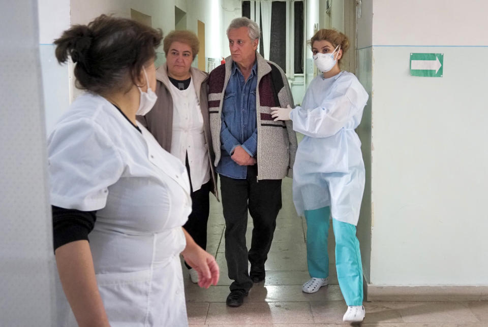 Medical personnel accompany a coronavirus patient in an infectious diseases clinic in Stepanakert, the separatist region of Nagorno-Karabakh, Tuesday, Oct. 20, 2020. Nagorno-Karabakh, which lies within Azerbaijan but has been under the control of ethnic Armenian forces since a war there ended in 1994, faces an outbreak of the coronavirus amid the largest outbreak of hostilities in more than a quarter-century. (AP Photo)