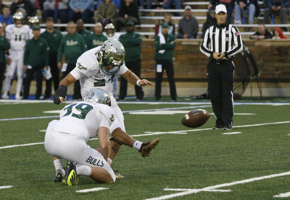 South Florida placekicker Coby Weiss (24) boots a field goal as punter Trent Schneider (39) holds in the first half of an NCAA college football game against Tulsa in Tulsa, Okla., Friday, Oct. 12, 2018. (AP Photo/Sue Ogrocki)