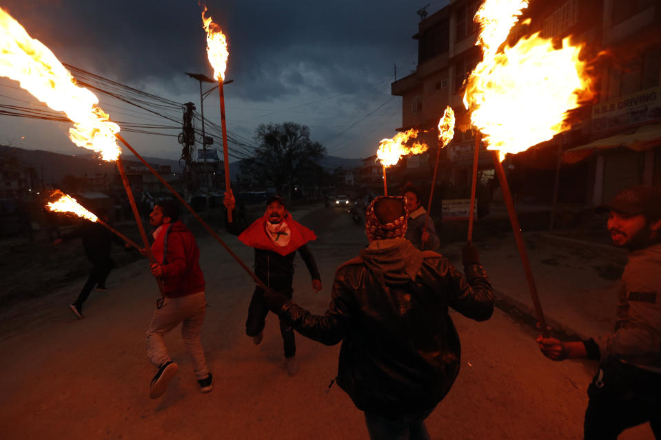 FILE - In this Monday, May 11, 2020, file photo, students affiliated with Nepal Student Union walk with torches during a protest against the Indian government inaugurating a new road through a disputed territory between India and Nepal, in Kathmandu, Nepal. India’s territorial dispute with its tiny Himalayan neighbour flared up with New Delhi rejecting Nepal’s claim for the second time within a week over an area where India has built a road leading to a revered Hindu pilgrimage site in the Tibetan plateau. In a strongly-worded statement issued late Wednesday, India objected to the Nepalese government releasing a revised official map of Nepal that includes parts of what it claims to be Indian territory. Nepal says the road passes through its territory. (AP Photo/Niranjan Shrestha, File)