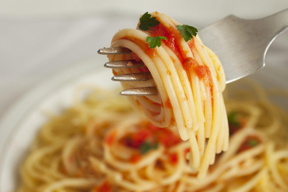 spaghetti in tomato sauce twirled onto a fork