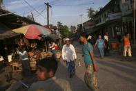 People walk between stalls at a market in Maungdaw town in northern Rakhine State November 11, 2014. REUTERS/Minzayar