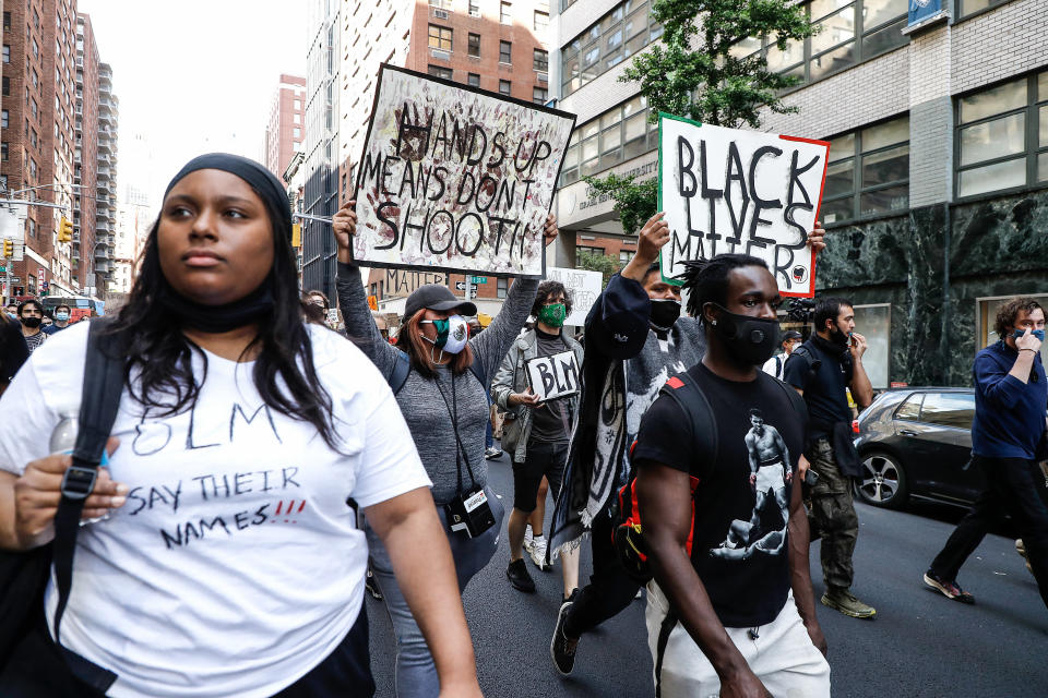 Protesters hold placards as they take part during a demonstration in response to the death of a Minneapolis man George Floyd.(John Lamparski/SOPA Images/LightRocket via Getty Images)