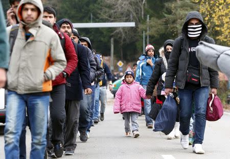 Migrants walk along a street after passing the Austrian-German border near Wegscheid, Germany, November 12, 2015. REUTERS/Michaela Rehle