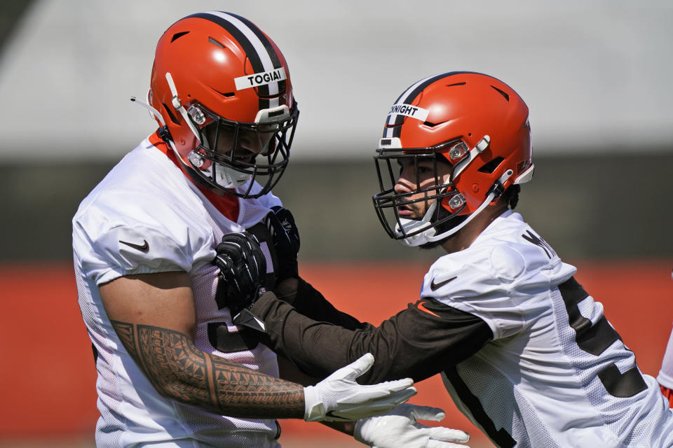 Cleveland Browns defensive tackle Tommy Togiai, left, and defensive end Romeo McKnight run a drill during an NFL football rookie minicamp at the team's training camp facility, Friday, May 14, 2021, in Berea, Ohio. (AP Photo/Tony Dejak)