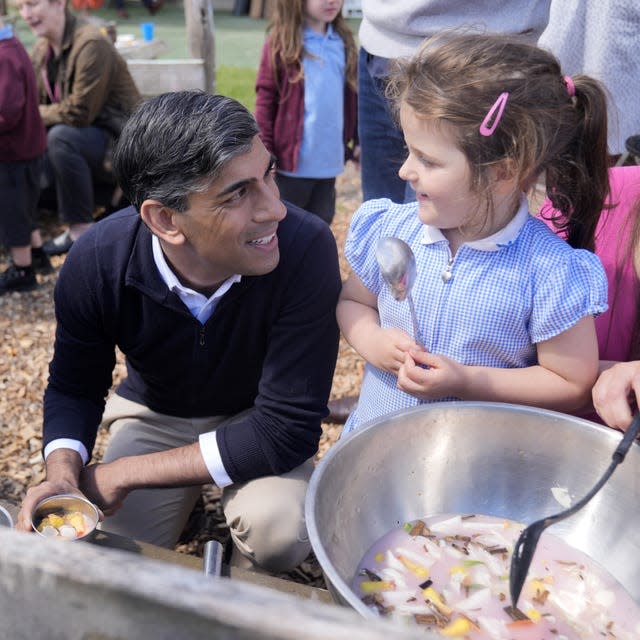 Rishi Sunak smiles at a young girl looking at him