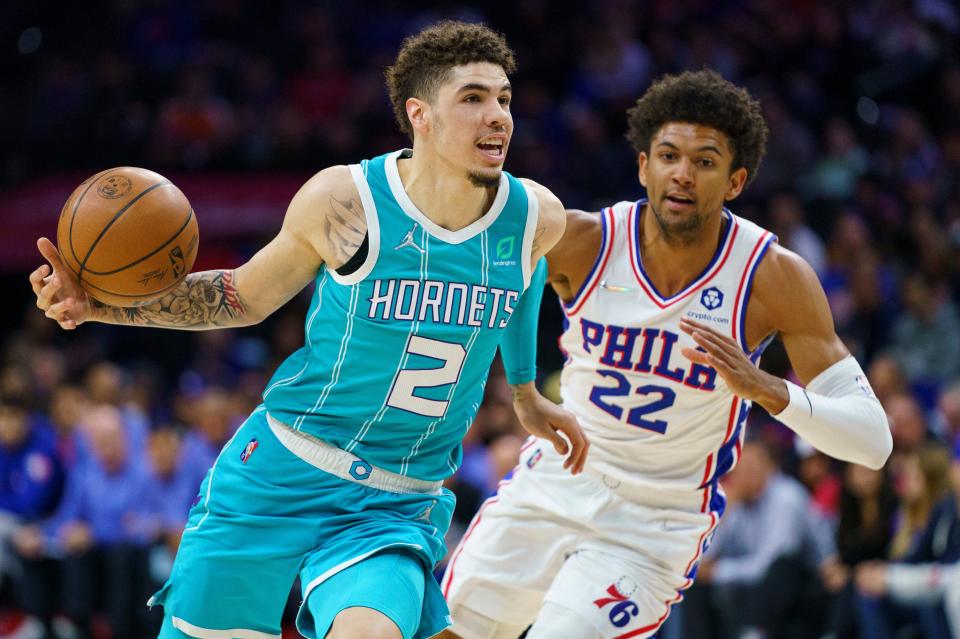 Charlotte Hornets' LaMelo Ball, left, drives to the basket against Philadelphia 76ers' Matisse Thybulle, right, during the first half of an NBA basketball game, Saturday, April 2, 2022, in Philadelphia. (AP Photo/Chris Szagola)