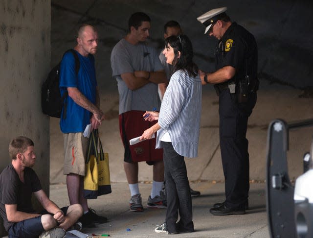 Terry DeMio talks to Justin Warfield, who was in active addiction in July 2017, under a bridge downtown in Cincinnati where about a dozen homeless people with heroin addiction stayed the night.