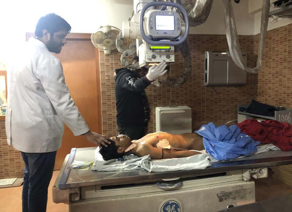 Doctors treat Mohammad Sameer, 17, for a gunshot wound to his chest that he said he received while standing on his family's apartment terrace watching Hindu mobs enter Mustafabad, at Guru Teg Bahadur Hospital in New Delhi, India, Wednesday, Feb. 26, 2020. “When Sameer was shot, I took him on my shoulders and ran downstairs," said the boy's father, Mohammad Akram. “But the when the mob saw us, they beat me and my injured son. He was bleeding very badly. While they were beating with sticks, they kept on chanting Jai Shri Ram slogans and threatened to barge inside our homes.” The clashes between Hindu mobs and Muslims protesting a contentious new citizenship law that fast-tracks naturalization for foreign-born religious minorities of all major faiths in South Asia except Islam escalated Tuesday. (AP Photo/Sheikh Saaliq)