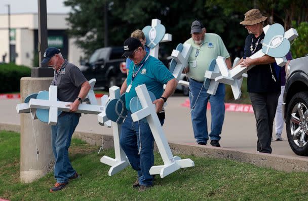 PHOTO: People from the Lutheran Church Charities carry crosses to a memorial being created at an entrance to the Allen Premium Outlets mall after the mass shooting occurred, May 8, 2023 in Allen, Texas. (Joe Raedle/Getty Images)