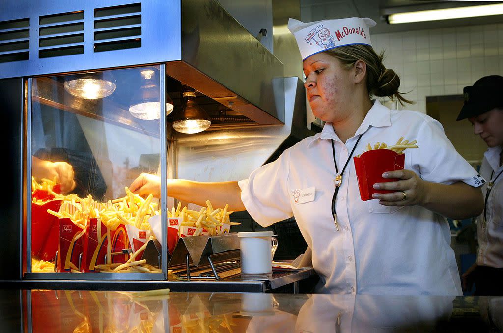 An employee serves up french fries at the world's oldest-operating McDonald's fast food restaurant