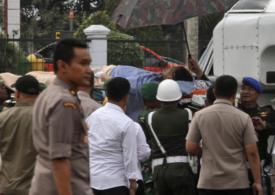 ALTERNATE CROP - Indonesian soldiers carry Indonesian Coordinating Minister for Politics, Law and Security Wiranto on a stretcher to a waiting helicopter to be evacuated to Jakarta, in Pandeglang, Banten province, Indonesia, Thursday, Oct. 10, 2019. Indonesian police officials say Wiranto and two other people, including a local police chief, have been wounded by a knife-wielding man and taken to a hospital during a visit to a western province. (AP Photo/Rafsanjani)