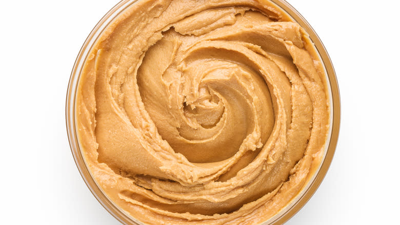 peanut butter in jar against white background