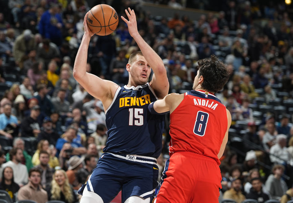 Denver Nuggets center Nikola Jokic, left, looks to shoot the ball as Washington Wizards forward Deni Avdija defends in the second half of an NBA basketball game Thursday, Feb. 22, 2024, in Denver. (AP Photo/David Zalubowski)