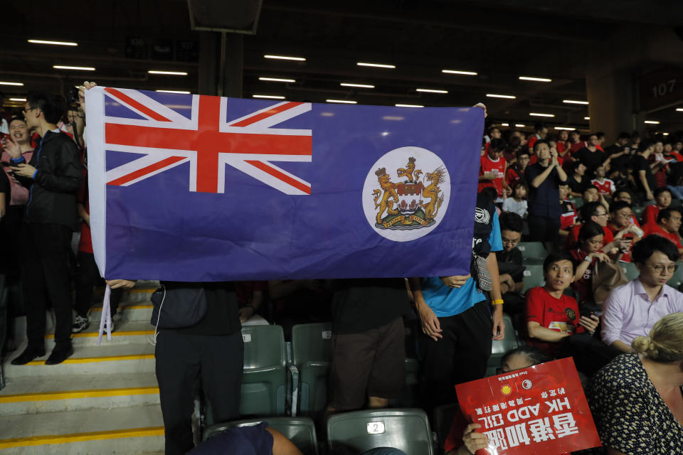 Hong Kong soccer fans hold a colonial era flag of Hong Kong during the FIFA World Cup Qatar 2022 and AFC Asian Cup 2023 Preliminary Joint Qualification Round 2 soccer match between Hong Kong and Iran, in Hong Kong, Tuesday, Sept. 10, 2019. The crowd broke out into "Glory to Hong Kong," a song reflecting their campaign for more democratic freedoms in the semi-autonomous Chinese territory. (AP Photo/Kin Cheung)