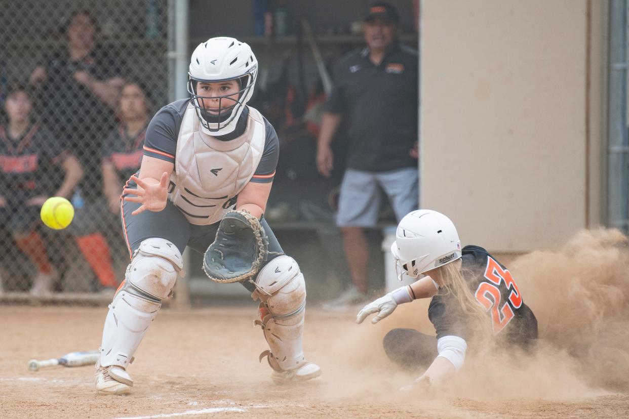 Dallas' Clara Woolsey (23) slides into home plate before Silverton's Braezen Henderson (17) makes the catch during a league matchup at Silverton High School on Wednesday, April 24, 2024, in Silverton, Ore.