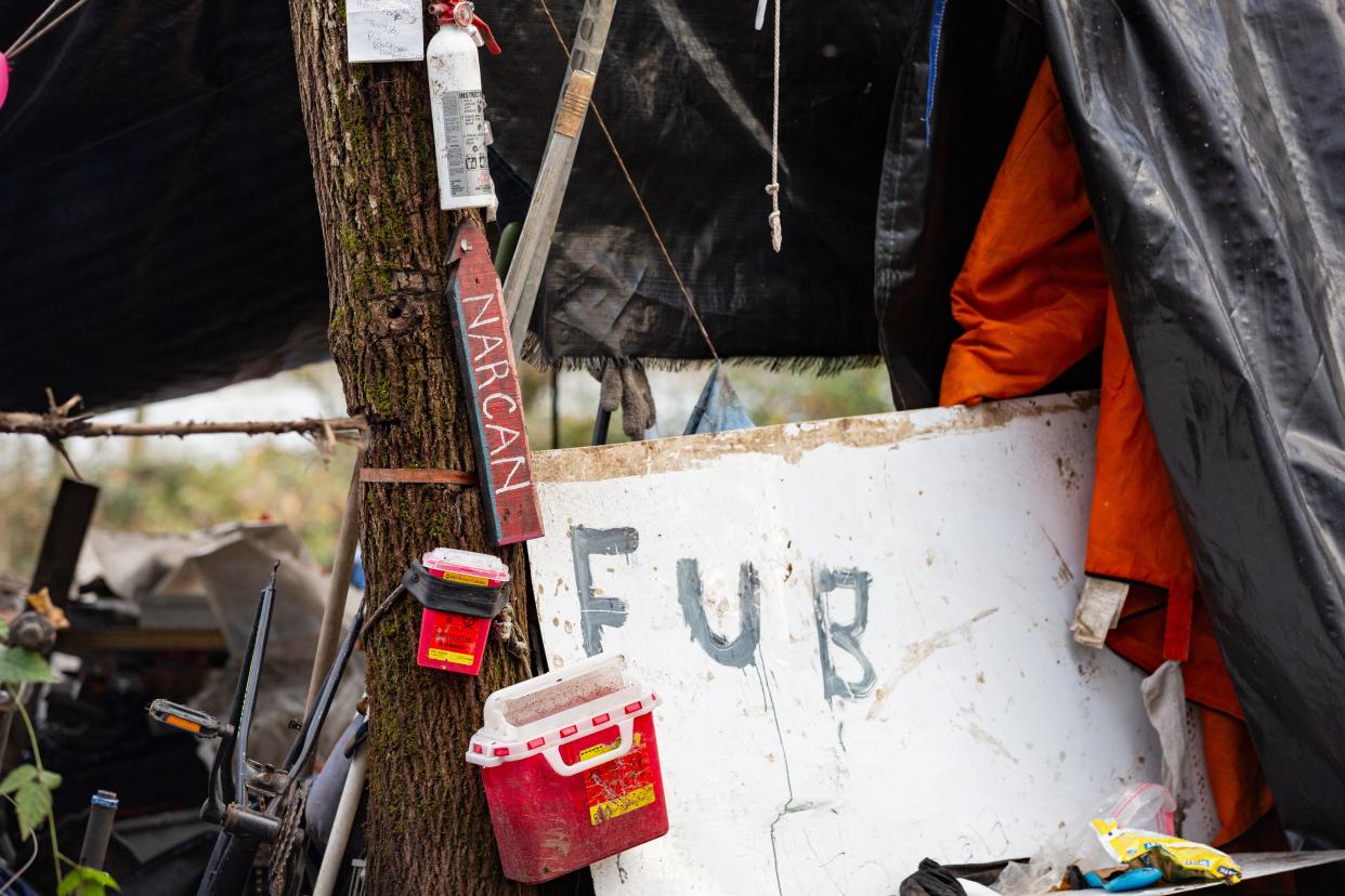 A Narcan sign is visible in December 2023 near unhoused people at Wallace Marine Park. A Salem Police detective told lawmakers the department's homelessness services team estimates 80-90% of unhoused individuals are under the influence of fentanyl.