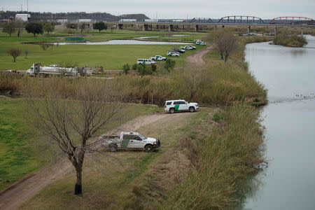U.S. border patrol vehicles, seen through the fence of the bridge (not pictured) connecting Eagle Pass, Texas, with Piedras Negras, Mexico, are stationed near the banks of Rio Bravo as seen from Piedras Negras, February 8, 2019. REUTERS/Alexandre Meneghini