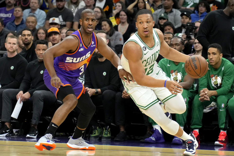 Boston Celtics forward Grant Williams passed Phoenix Suns guard Chris Paul, 3, in the first half of an NBA basketball game in Phoenix on Wednesday, Dec. 7, 2022.  (AP Photo/Rick Scuteri)
