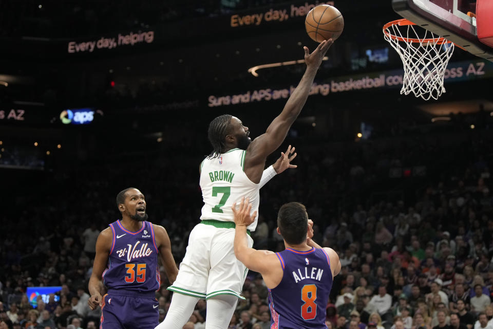 Boston Celtics guard Jaylen Brown (7) drives between Phoenix Suns forward Kevin Durant (35) and guard Grayson Allen (8) during the first half of an NBA basketball game, Saturday, March 9, 2024, in Phoenix. (AP Photo/Rick Scuteri)