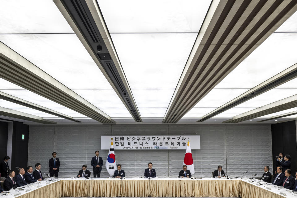 South Korea's President Yoon Suk Yeol, center, joins Masakazu Tokura, second right, chairman of Keidanen, the Japan Business Federation, and Kim Byong-joon , second left, acting chairman of the Federation of Korean Industries, as they attend a Japan-Korea Business Roundtable meeting in Tokyo Friday, March 17, 2023. (Philip Fong/Pool Photo via AP)